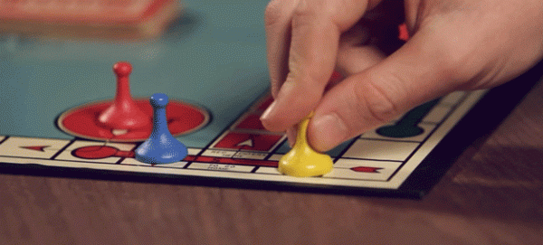 photo of a hand moving a game piece on a game board