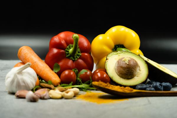 photo of garlic, carrot, red and yellow peppers, cherry tomatoes, and an avocado