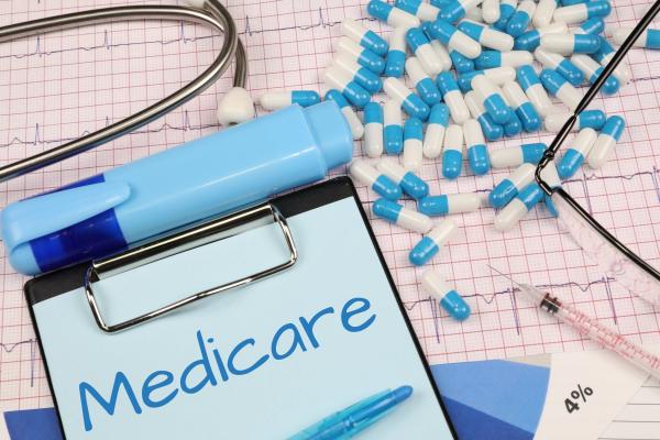 medicare written on a clipboard surrounded by pills and a stethoscope
