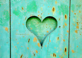 heart shape cut into blue green, weathered board
